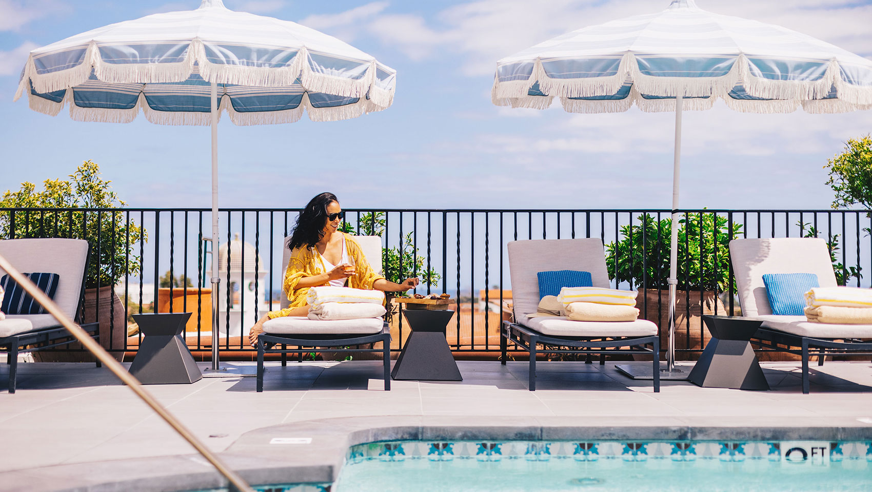woman sitting by rooftop pool